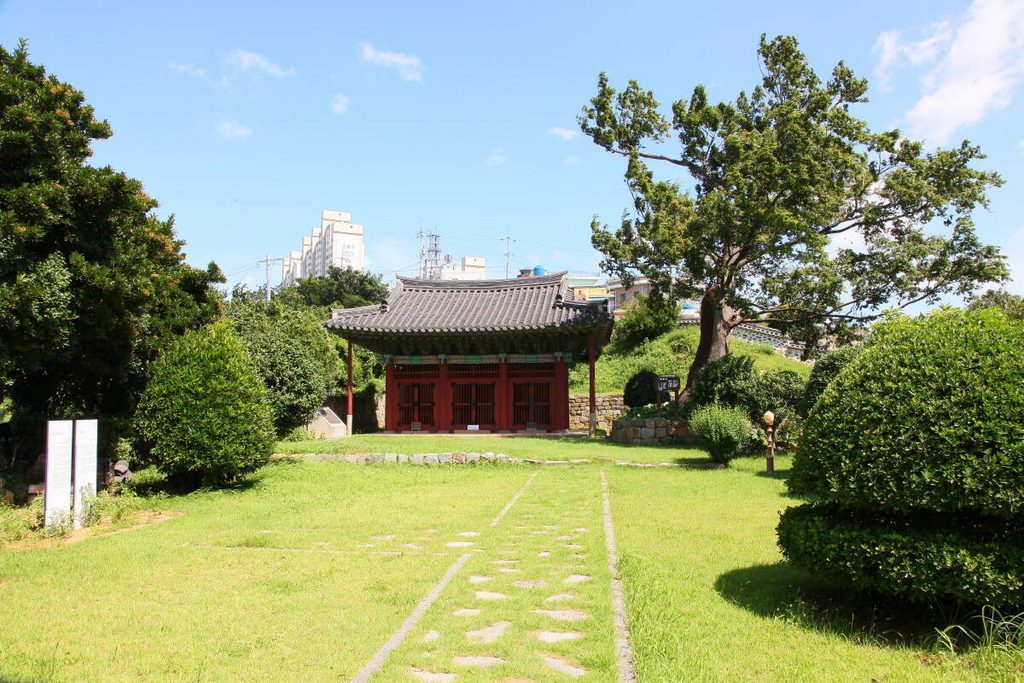 푸른 잔디와 나무 사이로 보이는 여수 고소대 비각 전경