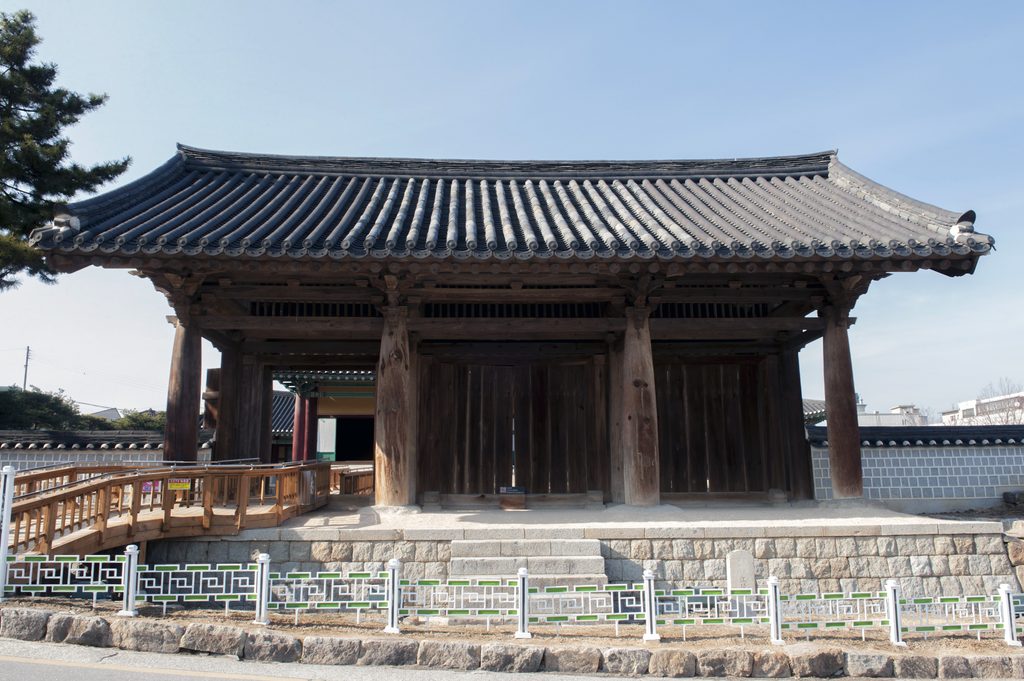 강릉 임영관 삼문의 기와지붕과 굵은 목조 기둥, 고려시대 주심포 양식을 보여주는 전통 건축물의 정측면.